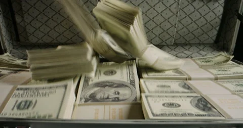 Packs of cash falling into a metal case filled with money. 100 dollar bills in a Stock Footage
