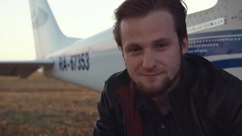 Packshot of a guy sitting by an airplane. Video stock 274064546