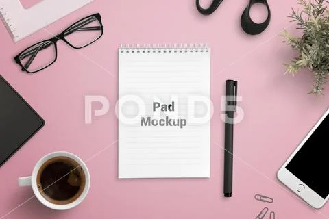 Pad mockup on office desk surrounded by office accessories and smart phone PSD-Vorlage