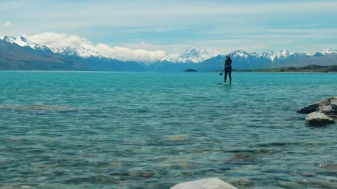 Paddle boarder on lake in front of Mount Cook Stock Footage 260368778