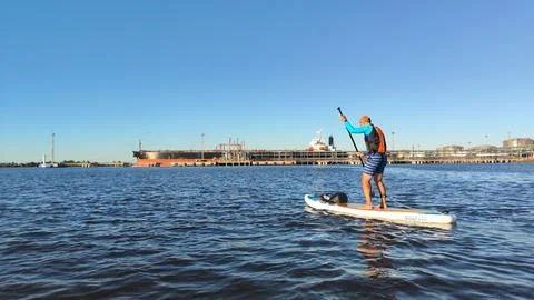 A paddle boarder sails on a sup board in the port of St. Petersburg. Stock Photos