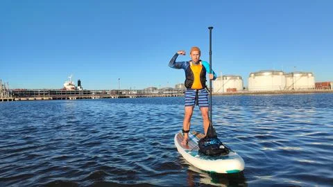 A paddle boarder sails on a sup board in the port of St. Petersburg. Stock Photos