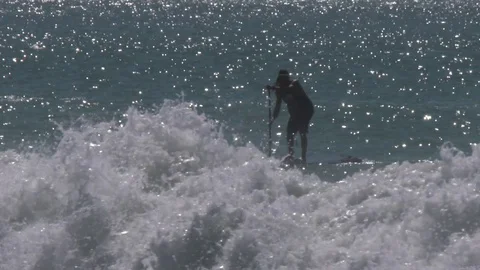 Paddle Boarder surfing in the ocean Stock Footage
