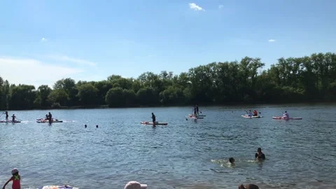 Paddle boarders on river beach Stock Footage 281524033