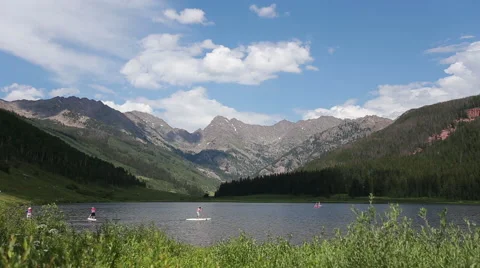 Paddle boarding in lake with mountain backdrop Stock Footage 40703914