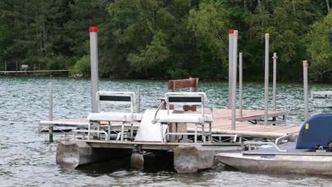 Paddle boats, at the dock, bobbing gently on the waves of the lake water. Stock Footage 160778080