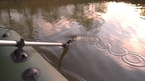 The paddle is lowered into the water during an inflatable boat ride on the lake Video stock 131966880
