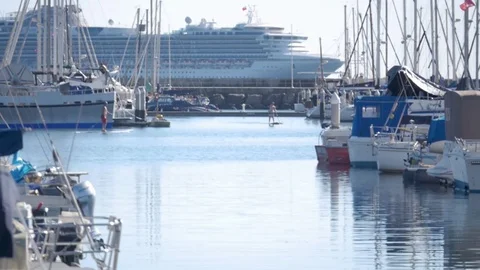 Paddle SUP boarding through harbor by sailboats and cruise ship Stock Footage 78032494