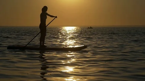 Paddleboard floats solar path at sunset Stock-Footage 83610202
