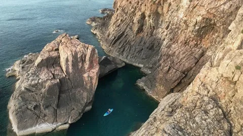 Paddleboarder in cove below Eo Gio cliffs, Quy Nhon Vietnam Stock Footage 337891572