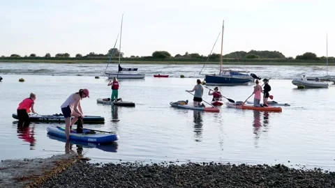 Paddleboarders setting off from Bosham Quay Stock Footage 133514707