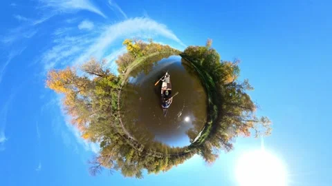 Paddling a canoe along a river surrounded by autumn colors. Tiny planet view Stock Footage 287147035