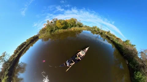 Paddling a canoe on a river under a blue sky, fall colors. Extreme wide angle Stock Footage 287146870