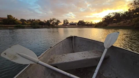 Paddling on a serene river at sunset with clear skies and calm waters Stock Footage 296498299