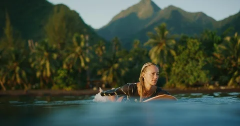 Paddling to surf at sunset Stock Footage 115688197