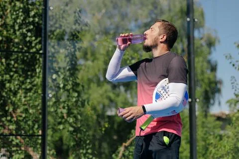 Padel Player Drinking Water During a Hydration Break on Outdoor Court Stock Photos