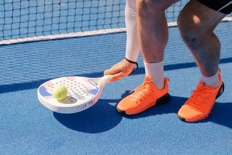 Padel player practicing ball control with racket on outdoor court Stock Photos