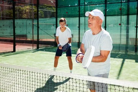 Padel players of different generations playing padel court Stock Photos