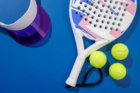Padel racket balls and face shield on blue court flat lay with copy space Stock Photos