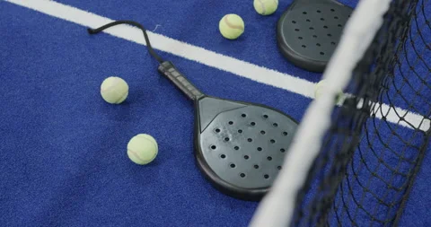 Padel rackets and balls scattered on blue court, ready for match Stock Footage 310212926