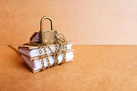 Padlock and key placed on a stack of books 写真素材