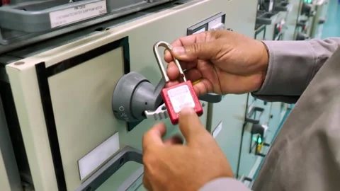 Padlock and warning tag secured on a main electrical isolation point demonstrate Stock Footage 335966768
