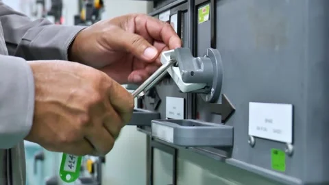 Padlock and warning tag secured on a main electrical isolation point demonstrate Stock Footage 335966773