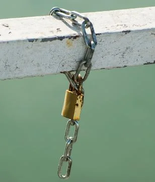 Padlock with chain caught on a bridge. Stock Photos