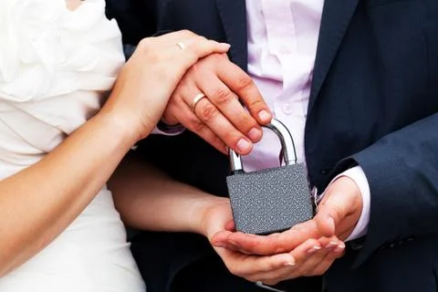 Padlock with the chain in the hands of just married Stock Photos