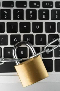 Padlock with chain on a laptop computer keyboard. Stock Photos