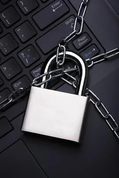 Padlock with chains on a black keyboard symbolizing security Stock Photos