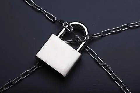 Padlock with chains on dark background, security concept Stock Photos