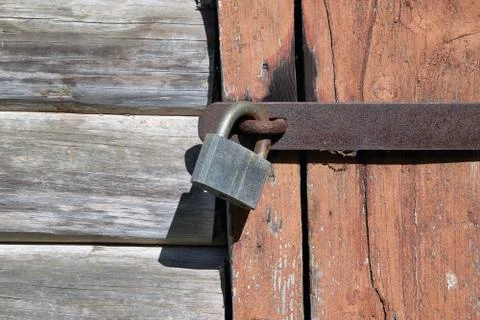 Padlock on the door of the old log structure. Stock Photos