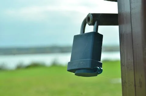 Padlock on gate clost to a beach Stock-Fotos