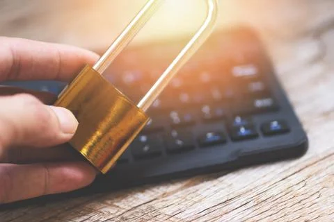 Padlock in hand data security systems computer with locked padlock on keyboar Foto stock