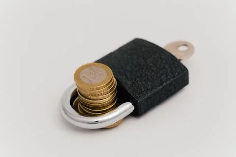 Padlock holding a stack of coins Stock Photos