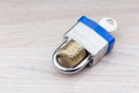 Padlock holding a stack of coins Foto stock