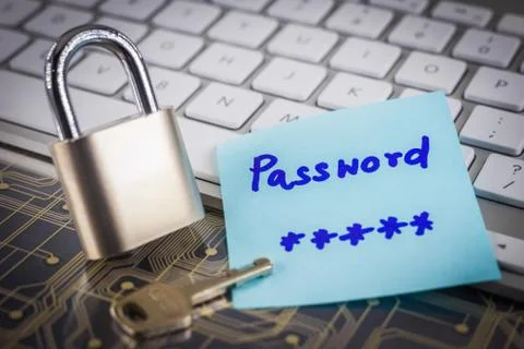 Padlock key with secret password note on circuit keyboard. Stock Photos
