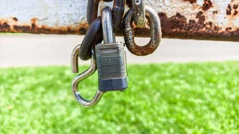 Padlock locking rusty chain with s hook Fotos de archivo