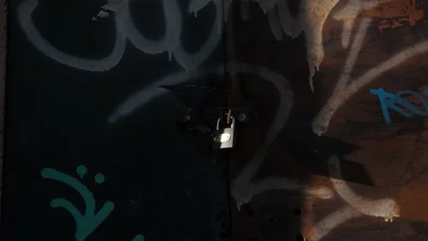 A padlock placed on some old doors with graffiti. Stock Footage 143713108
