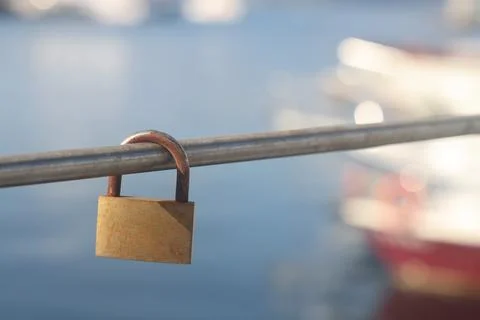 Padlock on the railing on the background of the sea and boats Stock Photos