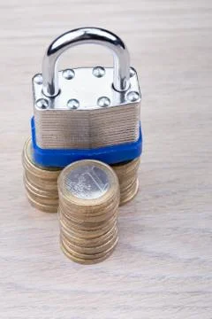 Padlock on a stack of coins Stock Photos