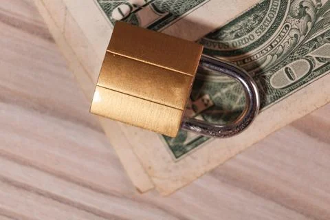 Padlock on the table with dollar bills. Stock Photos