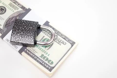 Padlock on a US dollar banknotes bundle Stock Photos