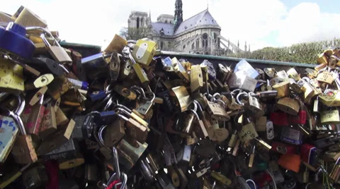 Padlocks all over the bridge at Pont des Arts in Paris with view on Notre Dame Stock Footage 38396428