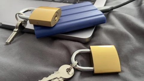 Padlocks and External SSD on Laptop for Data Privacy and Backup Security Stock Footage 340407555