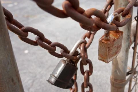Padlocks And Rusted Chains Secure Gate At Industrial Site Stock Photos