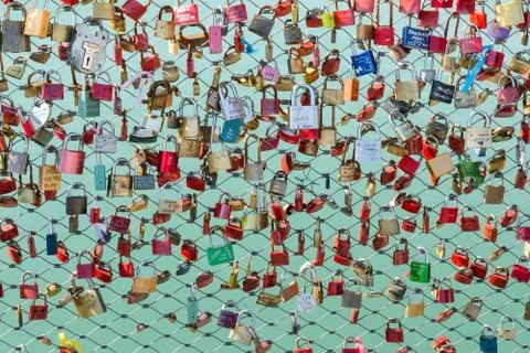 Padlocks hanging on the bridge over the river Stock Photos
