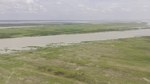 Padma River flowing beside vast green farmland and Bangladesh countryside Stock Footage 344514295