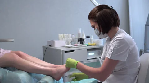 Padologist prepares the legs for the procedure. She wipes her feet with napkins Stock Footage 155992478